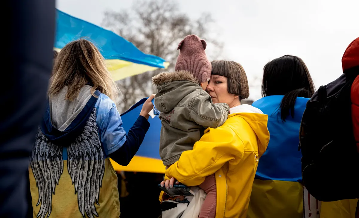 A mother and child among people with flags, symbolizing unity and protest.
