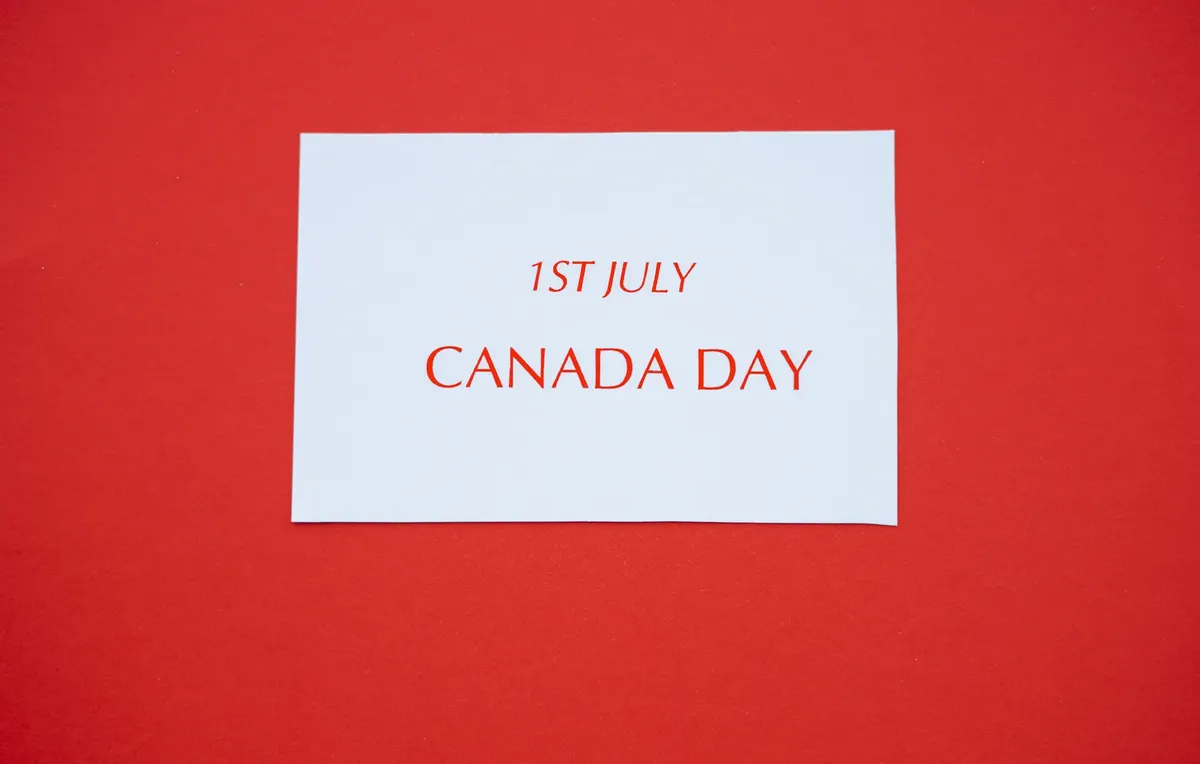 A white card with red text displaying '1st July Canada Day' on a red background.