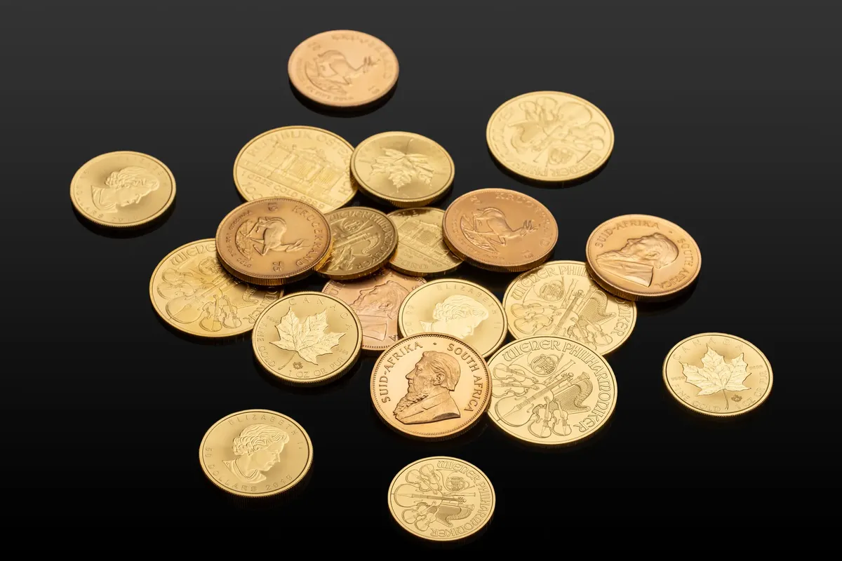 various international gold coins のクローズアップ。反射する黒い表面に置かれた、グローバル通貨が描かれています。